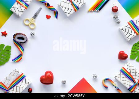 Rahmen aus Weihnachtsgeschenken mit Regenbogenband in LGBTQ Community Flag Farben. Flache Laie mit Weihnachtsdekor, Kopierraum. Stockfoto