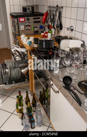 Küche nach einem größeren Abendessen, Kochparty, Spülmaschine, voll, mit gereinigtem Geschirr, schmutzige Gläser, Töpfe, Kochutensilien auf dem Waschbecken, warten zu sein Stockfoto