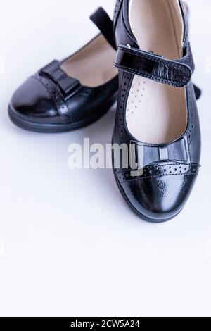 Modische schwarze stilvolle Mädchen Leder Slipper auf weißem Hintergrund. Modische Schulschuhe.elegante Kinderschuhe Stockfoto