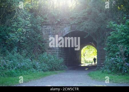 Licht am Ende des Tunnels - Standort des seit langem geschlossenen Molyneux Brow Railway Station, Clifton, England. Person, die im Tunnel steht, geht Stockfoto