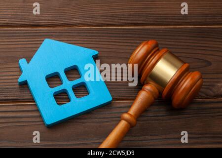 Abschnitt des Eigentums nach einer Scheidung oder dem Kauf oder Verkauf eines Hauses durch Auktion. Blaues Haus und Richtergavel Stockfoto