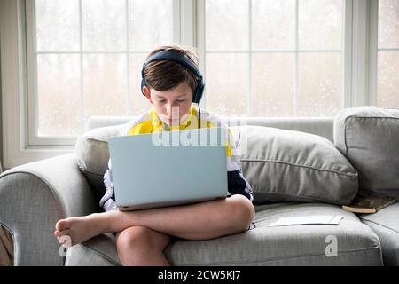 Preteen Boy tragen Kopfhörer funktioniert auf Laptop für virtuelle Schule Stockfoto