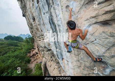 Mann klettert auf der Kalksteinklippe "White Mountain" in Yangshuo Stockfoto