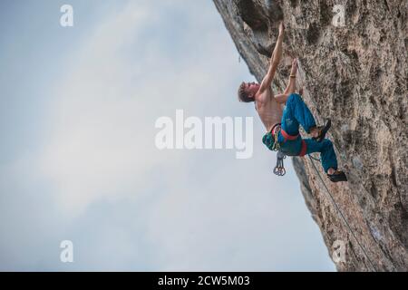 Mann klettert auf der Kalksteinklippe "White Mountain" in Yangshuo Stockfoto