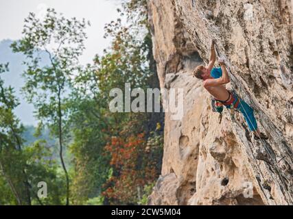 Mann klettert auf der Kalksteinklippe "White Mountain" in Yangshuo Stockfoto