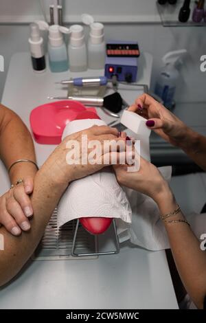 Senior Frau in Kosmetiksalon tun Maniküre mit Spezialist Stockfoto