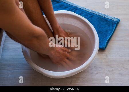 Männlich legte Hände und Füße in Bad mit heißem Wasser und Backpulver zu Hause. Stockfoto