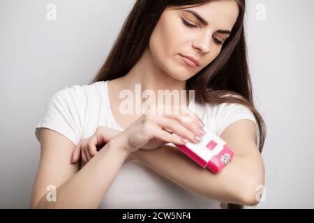 Eine Frau verwendet einen Epilierer, um Haare zu entfernen Stockfoto