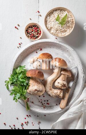 Zutaten für vegetarisches Risotto mit Steinpilzen und Petersilie Holztisch Stockfoto