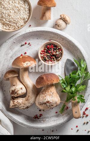 Zubereitungen für vegetarisches Risotto mit Steinpilzen und Petersilie Holztisch Stockfoto