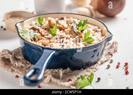 Leckeres Risotto mit Steinpilzen und Petersilie auf Holztisch Stockfoto