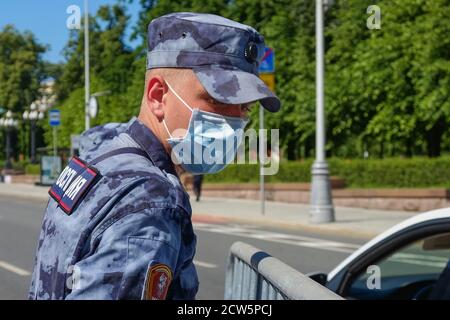 Junger Soldat von Russland Wache tragen Sommer Tarnung, Schutzmaske und Handschuhe arbeiten auf der Straße.Moskau, Russland, Juni 2020. Stockfoto