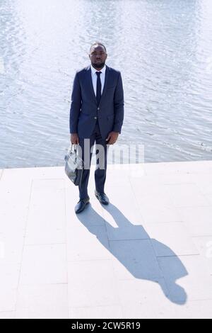 Junger afrikanischer Geschäftsmann in formalwear mit schwarzer Lederhandtasche Stockfoto