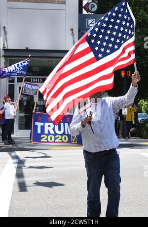 Ein schwarzer Mann mit amerikanischer Flagge bei der Pro Trump Pro Police Kundgebung an der Ecke NE4th und Bellevue Way NE in Bellevue, Washington am 4. Juli 2020 Stockfoto