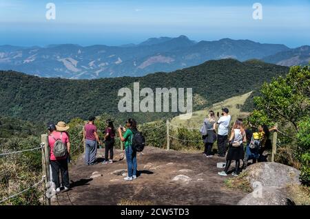 Touristen auf Pedra da Macela unteren Aussichtspunkt fotografieren und genießen die atemberaubende Berglandschaft Umgebung der Serra do Mar Region. Stockfoto