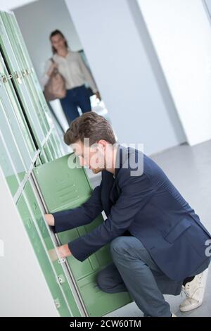 Schüler seine Buchhaltung in der Umkleide in der Universität Stockfoto