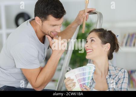 Junge Frau mit ein Farbmuster mit einem Maler Malerei Stockfoto