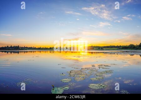 Wunderschöne Landschaft mit buntem Sonnenaufgang über dem See Stockfoto