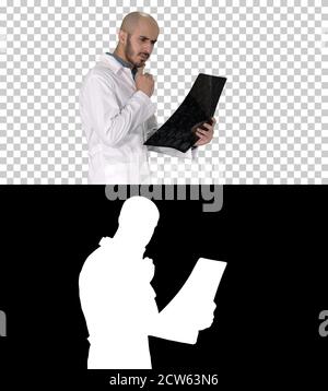 Junger männlicher Arzt, der einen MRT-Hirnscan liest und überprüft Wil Stockfoto