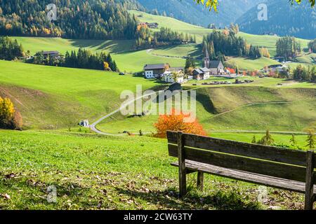 Die Bank mit Panoramablick auf das Dorf Santa Magdalena in Norditalien an den Hängen der Dolomiten im Tal des Val di Funes. Stockfoto