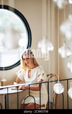 Frau, die in der Planerin schreibt Stockfoto