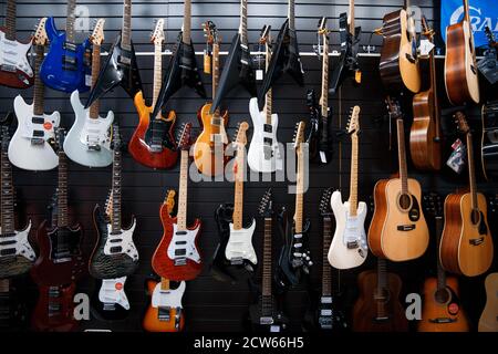 Zaporozhye/Ukraine- März 14 2020 : Gitarren hängen in einer Reihe an der Ladenwand. Stockfoto