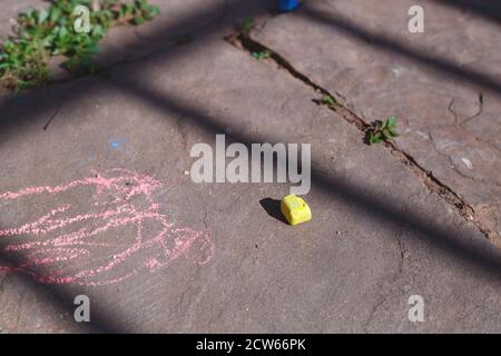 Ein Stück gelber Kreide liegt auf dem Asphalt Stockfoto