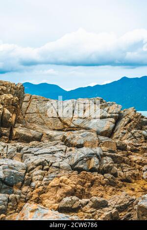 Schönheit vertikalen Panorama eingefasst Shabby Cliff Cumulus Wolke Himmel Berg Insel Hintergrund. Grau braun Stein Gestein Textur lebendige Farbe Foto. Konzept von Stockfoto