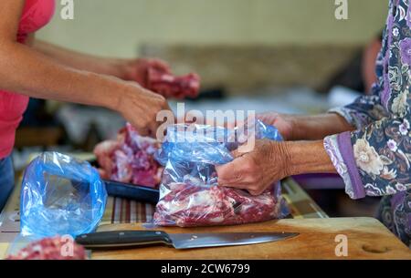 Kauf von Rindfleisch von der lokalen Metzger, anonyme Hände Umgang mit dem Fleisch Stockfoto