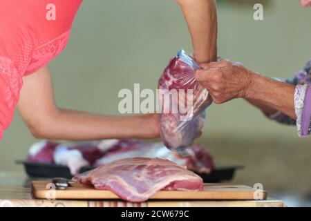 Kauf von Rindfleisch von der lokalen Metzger, anonyme Hände Umgang mit dem Fleisch Stockfoto