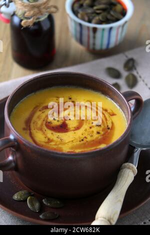 Kürbissuppe in Suppenschüssel als rustikale Tischdekoration Stockfoto