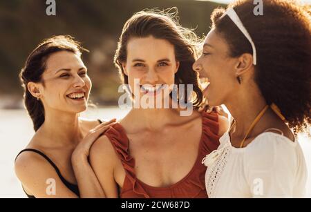Lächelnde Frauen stehen im Freien zusammen. Multiethnische Freundinnen im Urlaub Spaß haben. Stockfoto