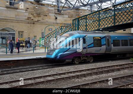 Passagiere auf dem Bahnsteig neben einer Trans Pennine Express Klasse 397 Nova Zug in Carlisle Station Stockfoto