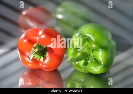 Grüne und rote Paprika auf einer Edelstahloberfläche. Stockfoto