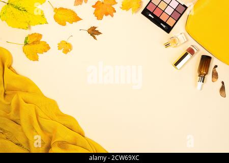 Flach Lay und Draufsicht auf Schönheit Make-up Produkte und Kosmetik auf Herbst gelben Blättern Hintergrund mit Copyspace gesetzt. Beauty-Konzept für Blogger. Stockfoto