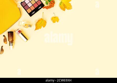 Flach Lay und Draufsicht auf Schönheit Make-up Produkte und Kosmetik auf Herbst gelben Blättern Hintergrund mit Copyspace gesetzt. Beauty-Konzept für Blogger. Stockfoto
