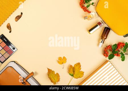 Flach Lay und Draufsicht auf Schönheit Make-up Produkte und Kosmetik auf Herbst gelben Blättern Hintergrund mit Copyspace gesetzt. Beauty-Konzept für Blogger. Stockfoto