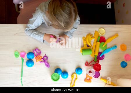 3 Jahre Mädchen kreative Künste. Kind Hände spielen mit bunten Ton Plastilin. Selbstisolation Covid-19, Online-Bildung, Homeschooling. Kleinkind Mädchen Stockfoto