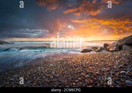 Stürmische Meereswellen und Schaum nach einem Gewitter bei Sonnenuntergang. Strand Marina di Cecina, Tyrrhenisches Meer, Toskana, Italien, Europa. Stockfoto