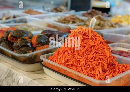 Straßenmarktstand mit Gemüse zum Verkauf. Fermentierte koreanische geriebene Karotten werden auf dem Markt der Bauern in Salzlake verkauft Stockfoto