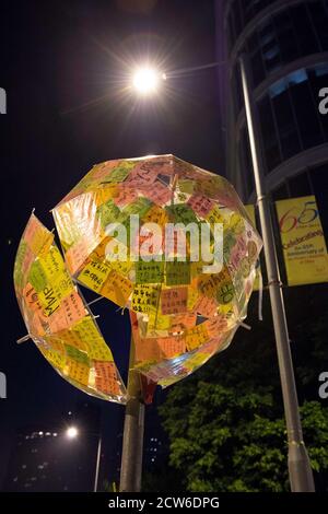 Hongkong, Hongkong, China. Oktober 2014. Slogans, Plakate und Protestkunst schmücken Säulen und Straßenschilder vor dem Hauptgeschäftsführer-Büro im LegCo-Gebäude, Tamar, Admiralität.Post-it-Notizen werden von Well-Wisher auf klaren Schirmen in einem Straßenschild hinterlassen. Quelle: Jayne Russell/ZUMA Wire/Alamy Live News Stockfoto