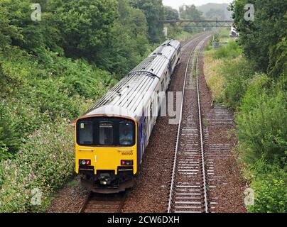 Ein Northern Diesel Zug verlässt Appley Bridge an einem nassen Morgen in Greater Manchester, der Bahnhof ist auf der Linie von Wigan Wallgate nach Southport. Stockfoto