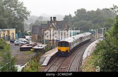 Ein Northern Zug kommt an einem nassen Morgen in Greater Manchester an der Station Appley Bridge an, der Bahnhof ist auf der Linie von Wigan Wallgate nach Southport. Stockfoto