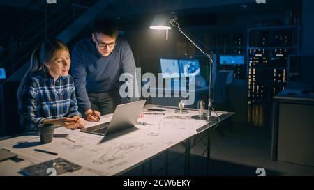 Industrial Engineering Einrichtung: Weibliche Ingenieurin arbeitet am Desktop-Computer, Projektmanagerin steht neben und erklärt die Besonderheiten der Aufgabe und Stockfoto