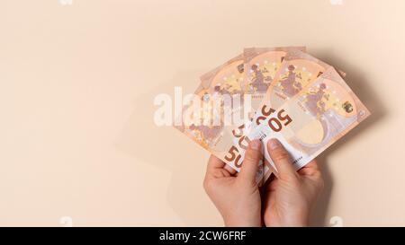 Ein Mann hält viele 50-Euro-Banknoten in den Händen. Ein Banner mit einem Platz für Text. Stockfoto