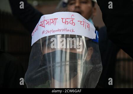 Kathmandu, Nepal. September 2020. Ein Protestant schaut während der Demonstration vor der chinesischen Botschaft in Kathmandu mit einem Gesichtsschutz und einer Gesichtsmaske auf.EINE zivilgesellschaftliche Gruppe in Nepal hat Proteste gegen China gestartet, weil sie angeblich Gebäude auf dem Territorium des Landes im Bezirk Humla gebaut haben. Die Aktivisten skandierten Slogans wie "Rückkehr Nepals Land" und "Stopp chinesischen Expansionismus". Kredit: SOPA Images Limited/Alamy Live Nachrichten Stockfoto