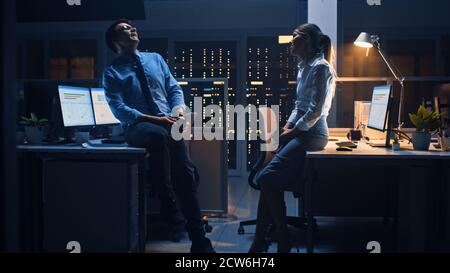 Spät in der Nacht im Corporate Office zwei Young Professionals freundlich chatten, News austauschen, über Job reden, Flirten Stockfoto