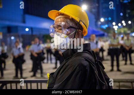 HONGKONG, HONGKONG SAR, CHINA: 5. OKTOBER 2019. Ein älterer, entschlossener Protestant auf der Polizeibarrikade vor dem Büro der Chefs in Le Stockfoto