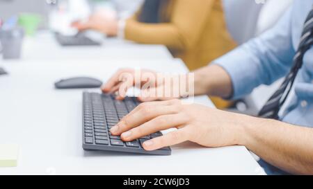 Nahaufnahme des Mannes, der mit der Maus auf einer Tastatur tippt. Geschäftsmann Büroangestellter arbeitet am Desktop-Computer in Bright Office Stockfoto