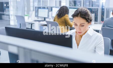 Schöne Geschäftsfrau, Ökonom, Aktienmakler verwendet Desktop-Computer, die Eingabe auf einer Tastatur, Arbeitsdokumente, Grafiken und Statistiken. In der Stockfoto